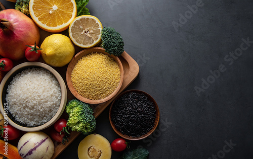 Bunch of fresh seasonal fruits, vegetables and grains of legumes on a black background