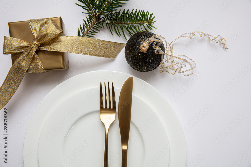 Table setting, xmas, new year. Gold cutlery on white set of dishes, white background