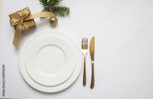 Table setting, xmas, new year. Gold cutlery on white set of dishes, white background