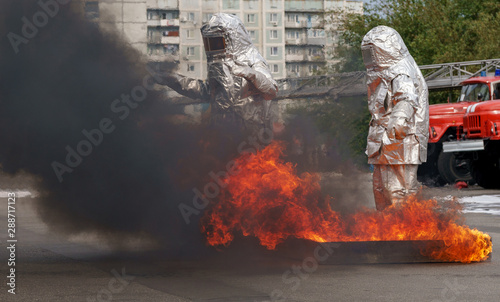 Fiteman in a fire proximity suit puts on fire.Fireman in a fire proximity suit which made to protect him from hazardous materials and when he extinguishes the fire photo