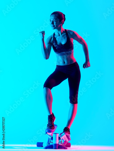 one mixed races woman exercsing Stepper fitness exercices isolated on blue blackground
