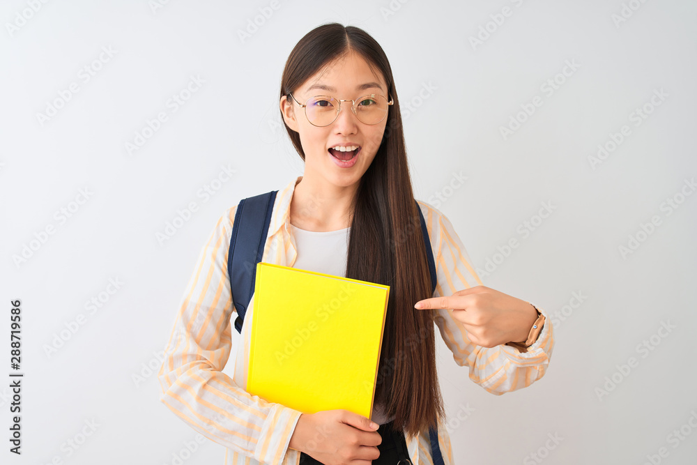Chinese student woman wearing glasses backpack book over isolated white background very happy pointing with hand and finger Chinese student woman wearing glasses backpack book over isolated white background very happy pointing with hand and finger