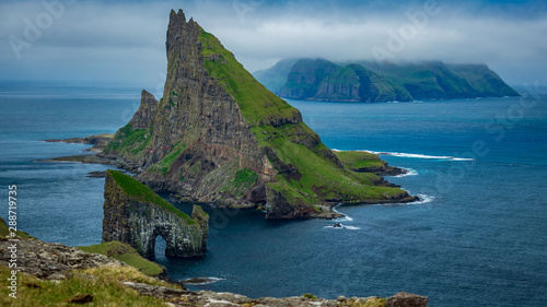 Fényképezés Amazing top view of Drangarnir gate in front of Tindholmur, Faroe Islands