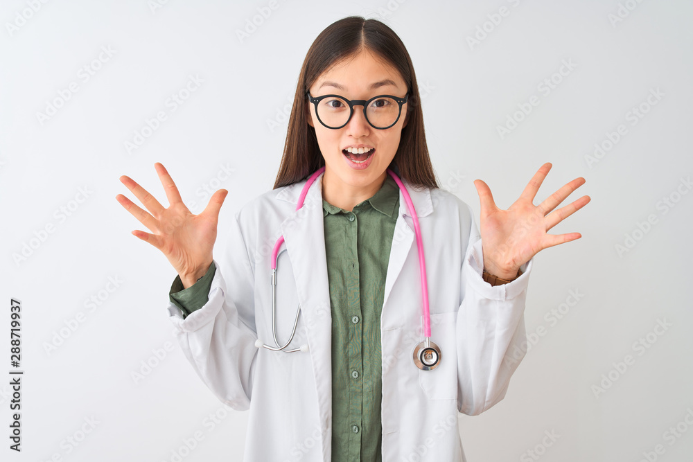 Young chinese dooctor woman wearing glasses stethoscope over isolated white background celebrating crazy and amazed for success with arms raised and open eyes screaming excited. Winner concept Young chinese dooctor woman wearing glasses stethoscope over isolated white background celebrating crazy and amazed for success with arms raised and open eyes screaming excited. Winner concept