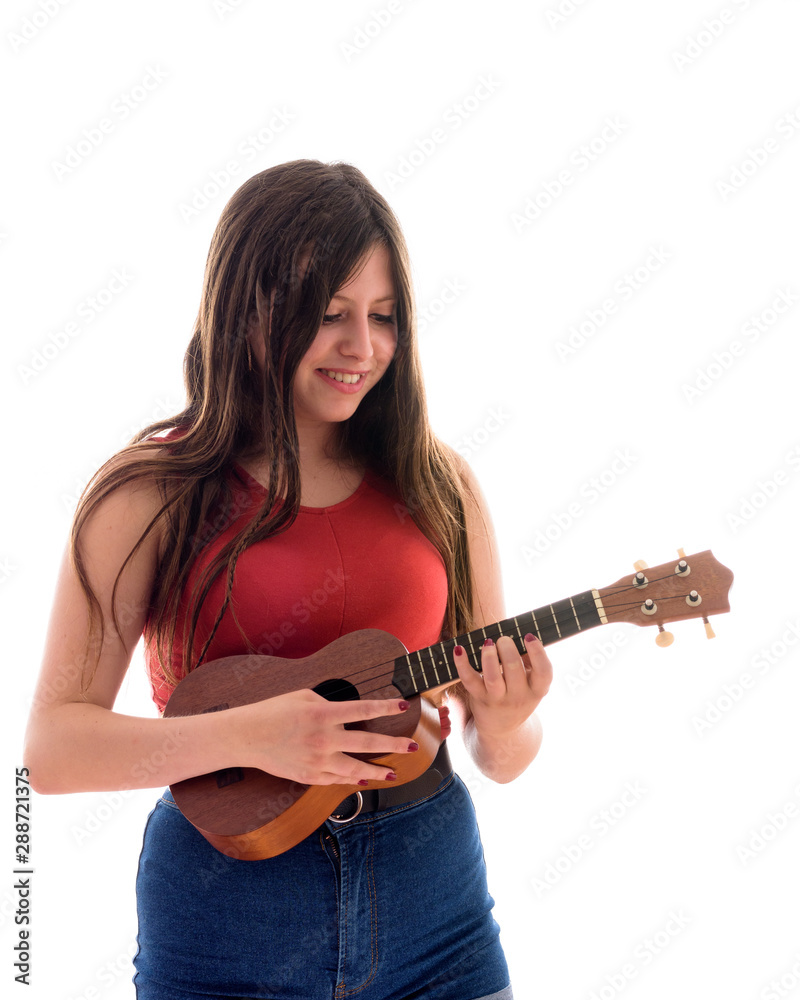 Teenage girl playing a ukelele, young artist with her musical instrument isolated Teenage girl playing a ukelele, young artist with her musical instrument isolated