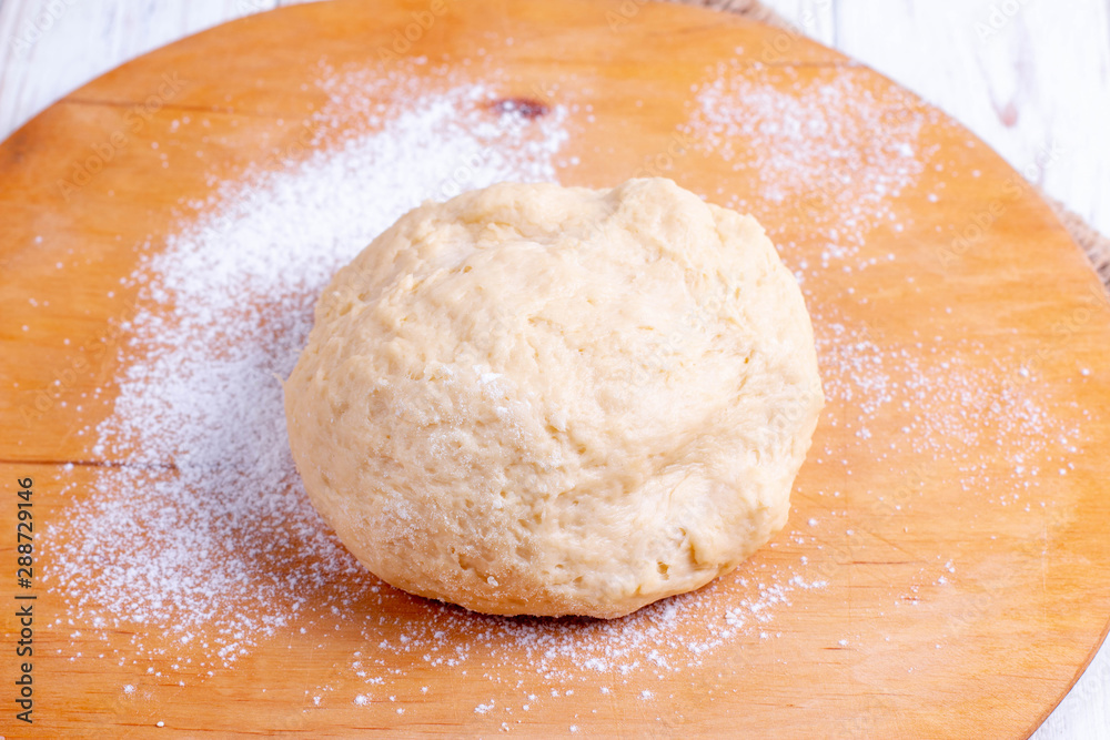 Raw wheat dough on cutting board Raw wheat dough on cutting board