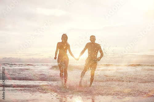 lovers run along the beach / guy and girl run along the summer sea beach, rest on the sea honeymoon