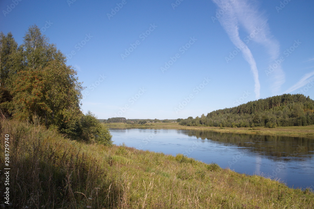 riverbank in the countryside blue sky traces of aircraft riverbank in the countryside blue sky traces of aircraft