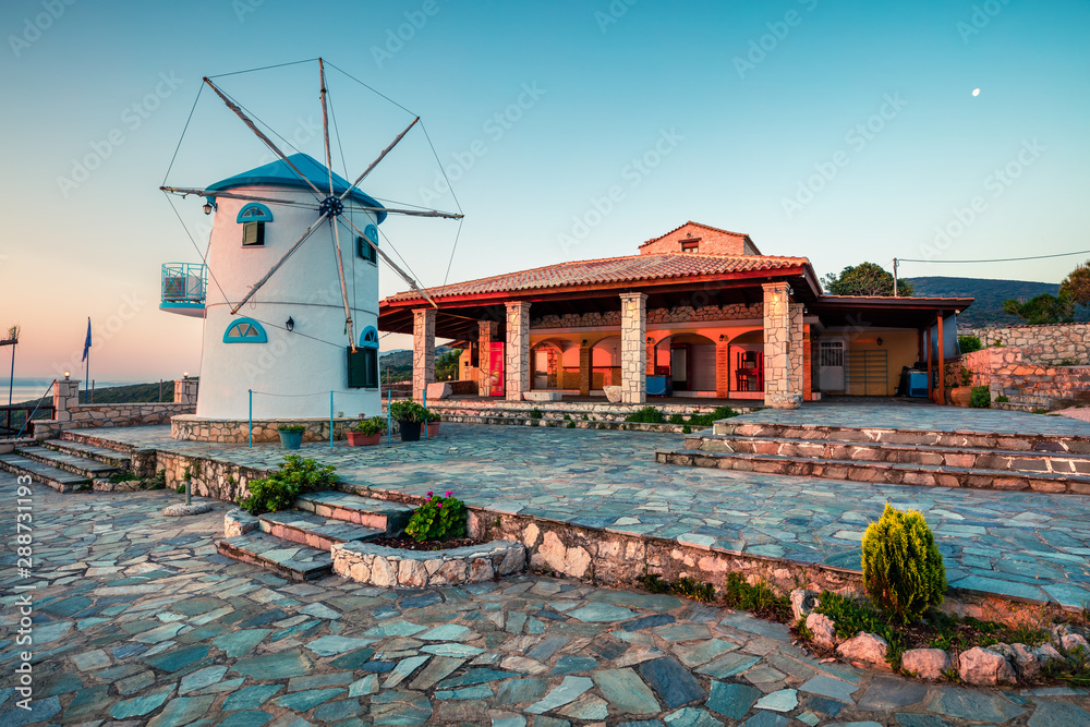 Beautiful morning view of Potamitis Windmill. Colorful spring sunrise on Zakynthos island, Korithi location, Ionian Sea, Greece, Europe. Beauty of countryside concept background.