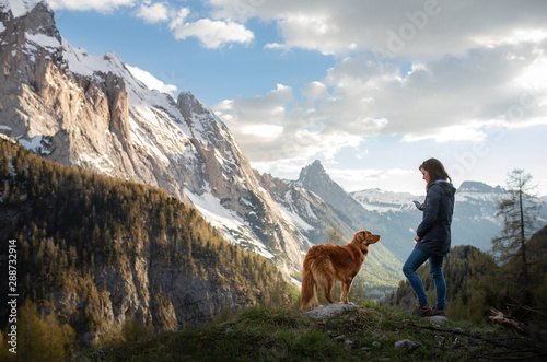 girl with a dog in the mountains. Autumn mood. Traveling with a pet. Nova Scotia Duck Tolling Retriever