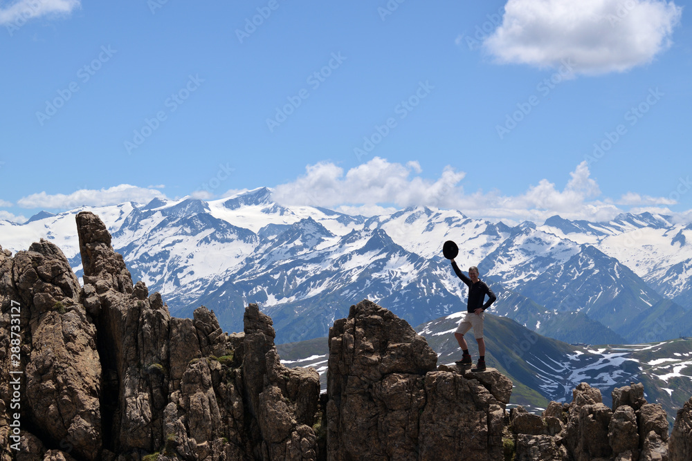 Happy mountain hiker on top of Grosser Rettenstein with Hohe Tauern mountain range in the back
