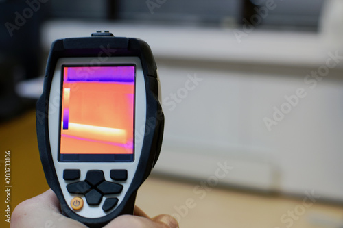 Thermal imaging camera, checking heat leaks at the house. Copy space. photo