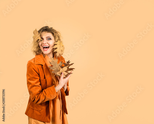 Smiling woman with autumn leaf. Fashion trends for fall. Leaf fall. Autumn woman with golden leaves. Autumnal foliage. Autumn clothing and color trends. Autumn sale. Fashion woman with leaves.