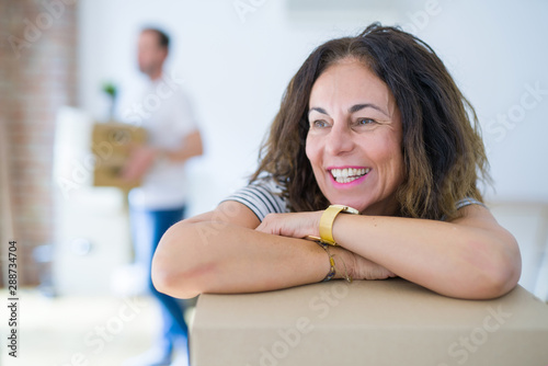 Middle age senior couple moving to a new house, woman smiling happy in love with new apartment