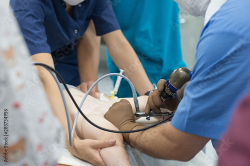 A team of urologist doctors performing a cystoscopy using a cystoscope. In a sterile operating room. close-up photo