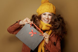 smiling young woman showing black dotted shopping bag