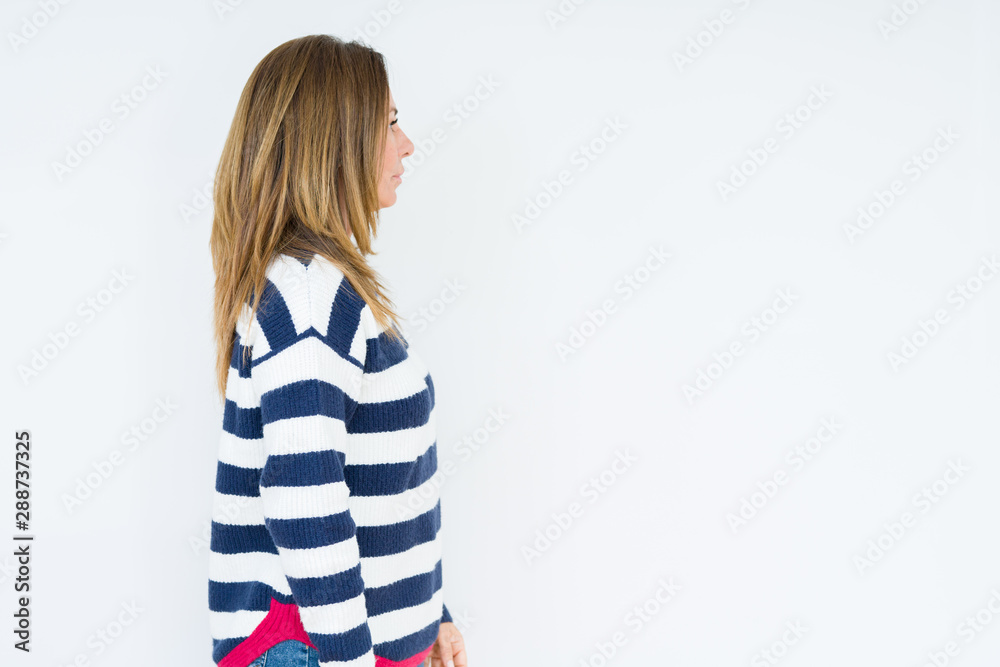 Beautiful middle age woman wearing navy sweater over isolated background looking to side, relax profile pose with natural face with confident smile. Beautiful middle age woman wearing navy sweater over isolated background looking to side, relax profile pose with natural face with confident smile.