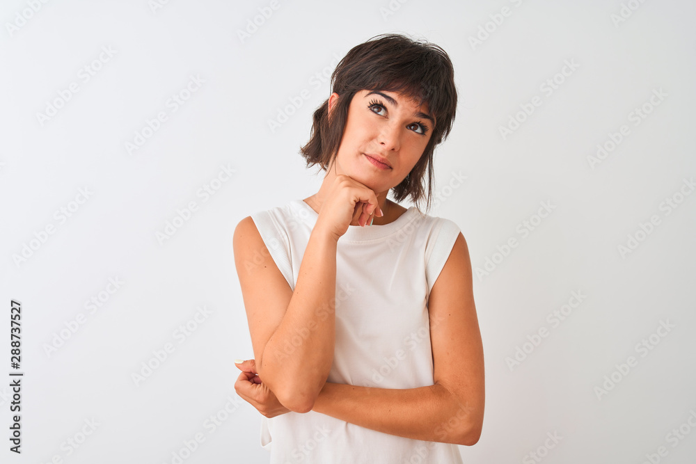 Young beautiful woman wearing casual t-shirt standing over isolated white background with hand on chin thinking about question, pensive expression. Smiling with thoughtful face. Doubt concept. Young beautiful woman wearing casual t-shirt standing over isolated white background with hand on chin thinking about question, pensive expression. Smiling with thoughtful face. Doubt concept.