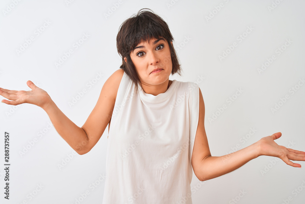 Young beautiful woman wearing casual t-shirt standing over isolated white background clueless and confused expression with arms and hands raised. Doubt concept. Young beautiful woman wearing casual t-shirt standing over isolated white background clueless and confused expression with arms and hands raised. Doubt concept.