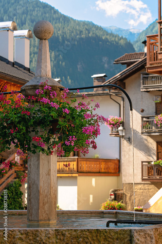 Typical fountain in the small town town Imer, Dolomites, Italy. close up. Sunny bright day. photo