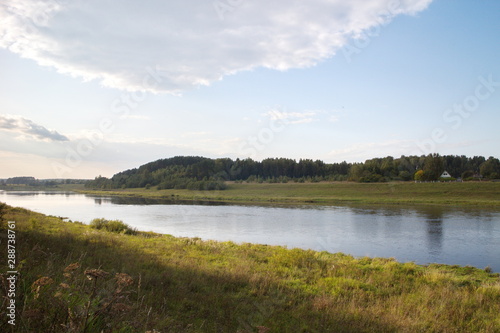 by the river in the countryside on a summer evening