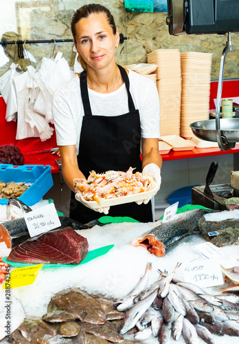 Saleswoman demostrating shrimps photo