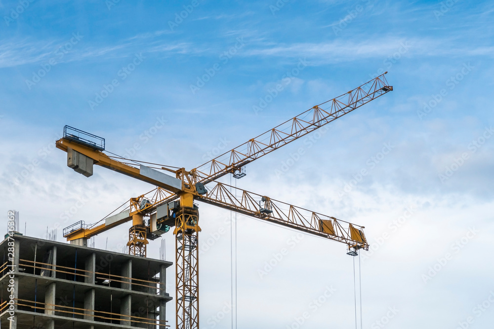 Building construction site. 2 yellow tower cranes against blue sky. Building construction site. 2 yellow tower cranes against blue sky.