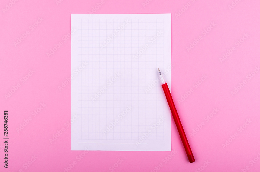 A white sheet of paper for drawings, texts, letters and notes, next to a red pen lies on a pink background A white sheet of paper for drawings, texts, letters and notes, next to a red pen lies on a pink background
