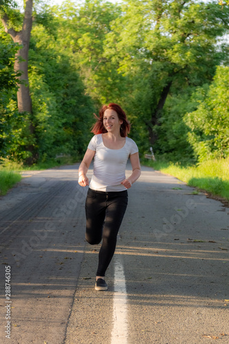 woman with white shirt runs on a street © funkenzauber