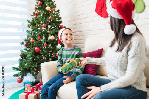 Woman Giving Gift To Excited Son At Home