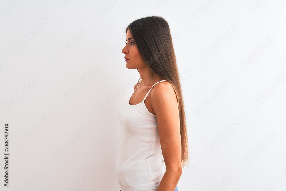 Young beautiful woman wearing casual t-shirt standing over isolated white background looking to side, relax profile pose with natural face with confident smile. Young beautiful woman wearing casual t-shirt standing over isolated white background looking to side, relax profile pose with natural face with confident smile.