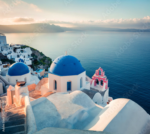 Sunny morning view of Santorini island. Stunning spring sunrise on the famous Greek resort Fira, Greece, Europe. Traveling concept background. Artistic style post processed photo.