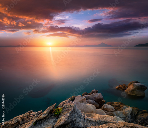 Amazing landscape of sunrise at sea. Colorful morning view of dramatic sky, seascape and rock. Long exposure image. Greece. Mediterranean Sea. Concept of nature background.