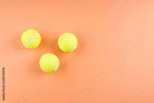 Three Tennis balls on orange abstract background. Competition concept © tenkende