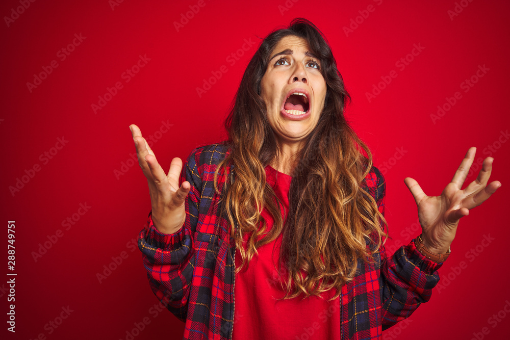Young beautiful woman wearing casual jacket standing over red isolated background Doing peace symbol with fingers over face, smiling cheerful showing victory Young beautiful woman wearing casual jacket standing over red isolated background Doing peace symbol with fingers over face, smiling cheerful showing victory