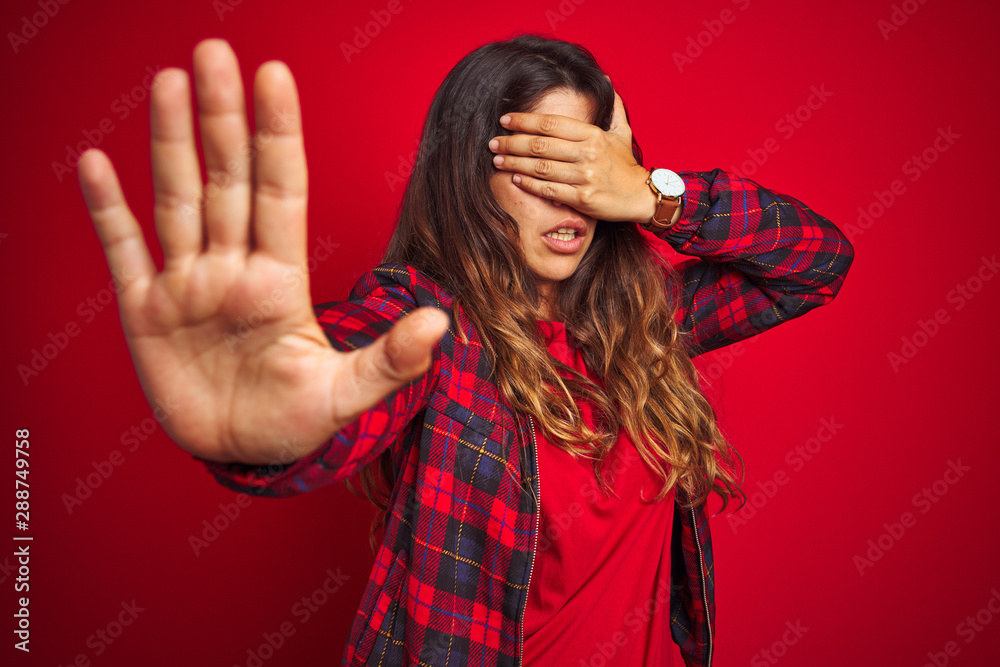 Young beautiful woman wearing casual jacket standing over red isolated background smiling cheerful offering hands giving assistance and acceptance. Young beautiful woman wearing casual jacket standing over red isolated background smiling cheerful offering hands giving assistance and acceptance.