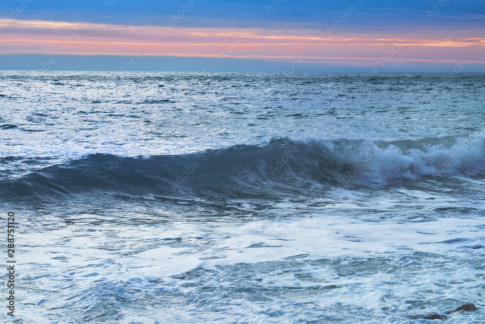 Sea landscape with big waves at sunset