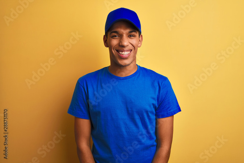 Young handsome arab delivery man standing over isolated yellow background with a happy and cool smile on face. Lucky person.