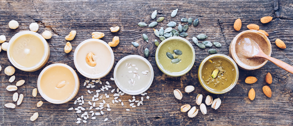 Obraz premium Nuts and seeds butter in glass jars