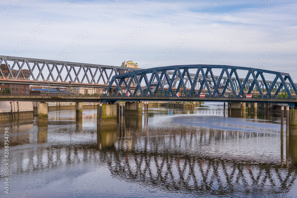 Fototapeta premium Railroad bridges across the Billhafen at the north-east end of the inland port in Hamburg. The water canal is an anabranch of the Elbe river