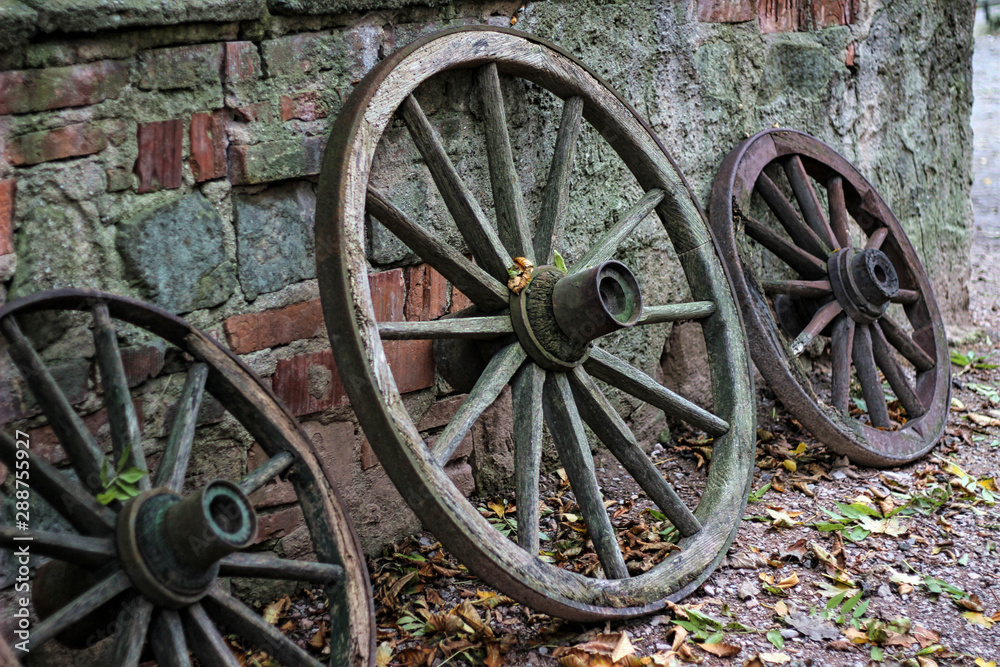 Detenice castle, Bohemian region, Czech Republic. Old wooden wheels standing against a wall.