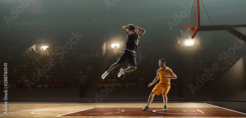 Basketball players in action with the ball. Basketball court with spectators. Dunking