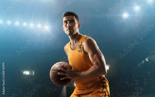 Professional basketball player on floodlit basketball arena with the ball © TandemBranding