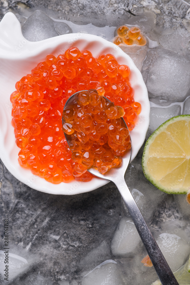 fresh red salmon caviar in spoon. served with lime around ice. macro shot. Protein luxury delicacy healthy food fresh red salmon caviar in spoon. served with lime around ice. macro shot. Protein luxury delicacy healthy food