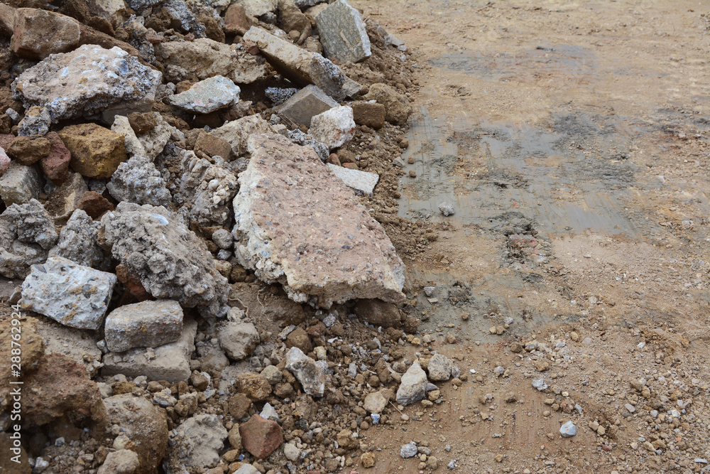 Broken pieces of concrete and bricks next to excavated ground Broken pieces of concrete and bricks next to excavated ground