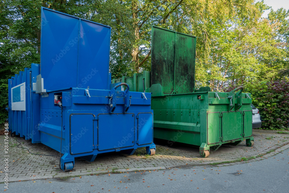 in the courtyard of a hospital there are two garbage compactors next to each other, one for garbage, the other for paper and cardboard in the courtyard of a hospital there are two garbage compactors next to each other, one for garbage, the other for paper and cardboard