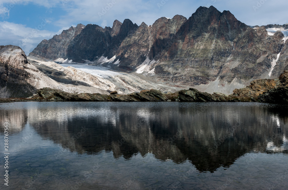 cime della valmalenco riflesse in un lago alpino di alta quota