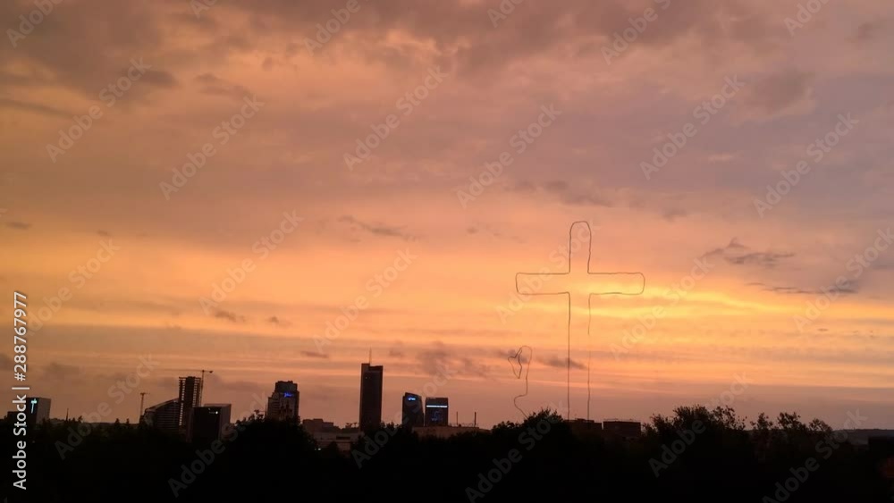Praying by the cross over city at sunset Praying by the cross over city at sunset