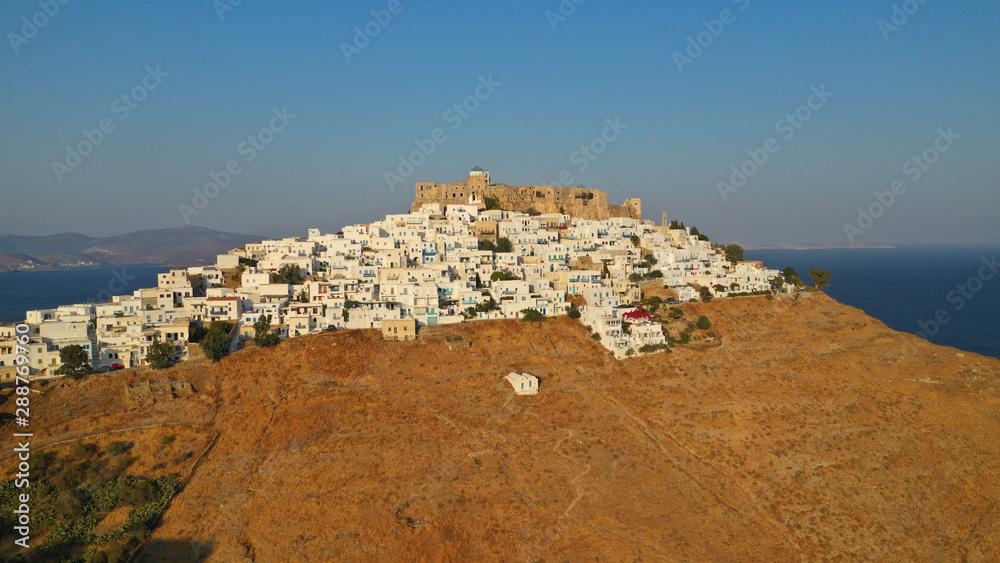 Aerial drone photo of iconic medieval fortified castle overlooking the deep blue Aegean sea in Chora of Astypalaia island, Dodecanese islands, Greece