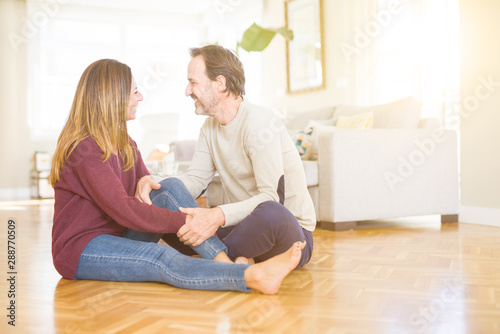 Beautiful romantic couple sitting together on the floor at home